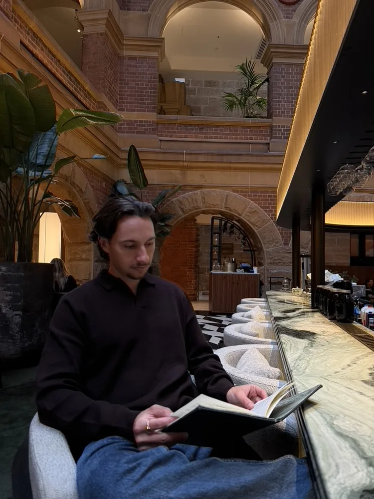Jack reading a book in a hotel lobby